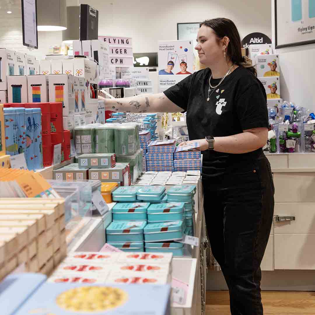 Employee from Flying Tiger Copenhagen in Frederiksberg stocking items on the shelves.